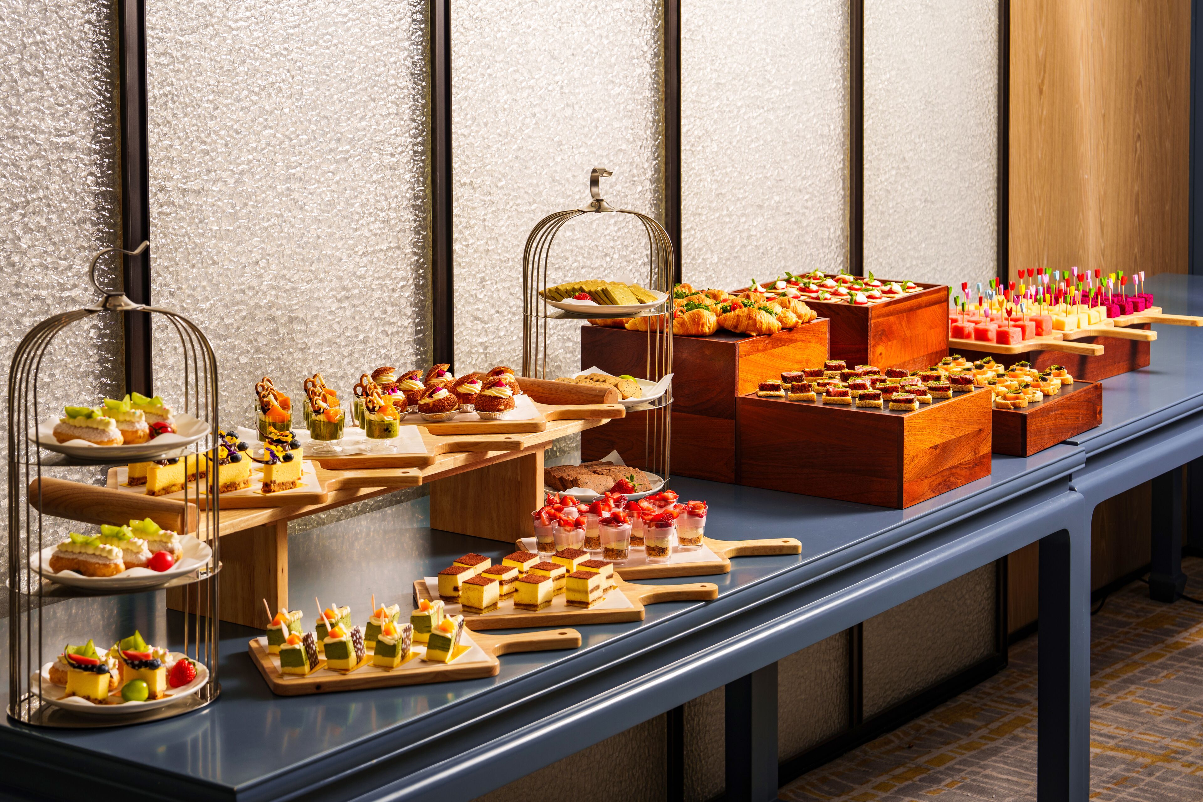 Una mesa de buffet con diferentes platillos y postres.