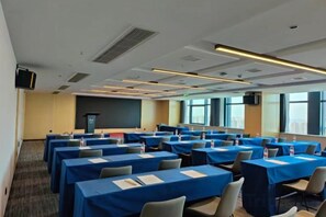 A conference room with multiple tables, chairs, and a podium. - Changsha Xingsha Haichuang Center Hotel (Changsha)