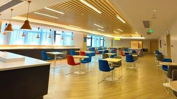 A modern dining area with a long counter and multiple tables and chairs.