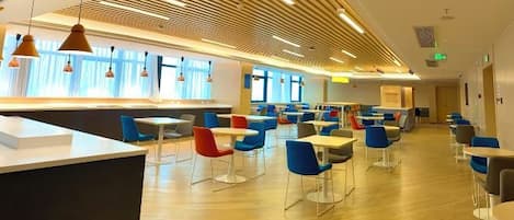 A modern dining area with a long counter and multiple tables and chairs.