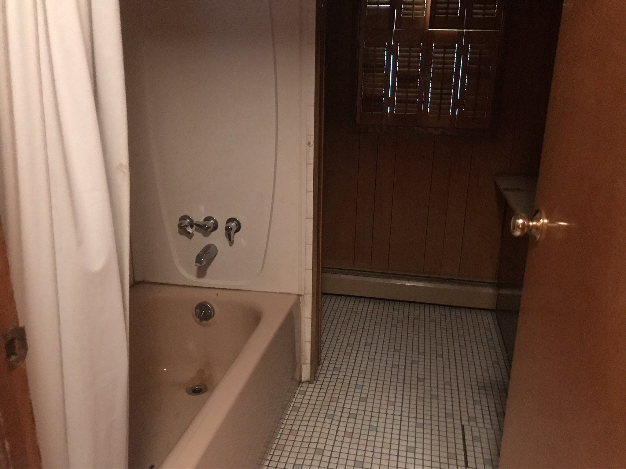 A bathroom with a bathtub, a toilet, and a shower area.