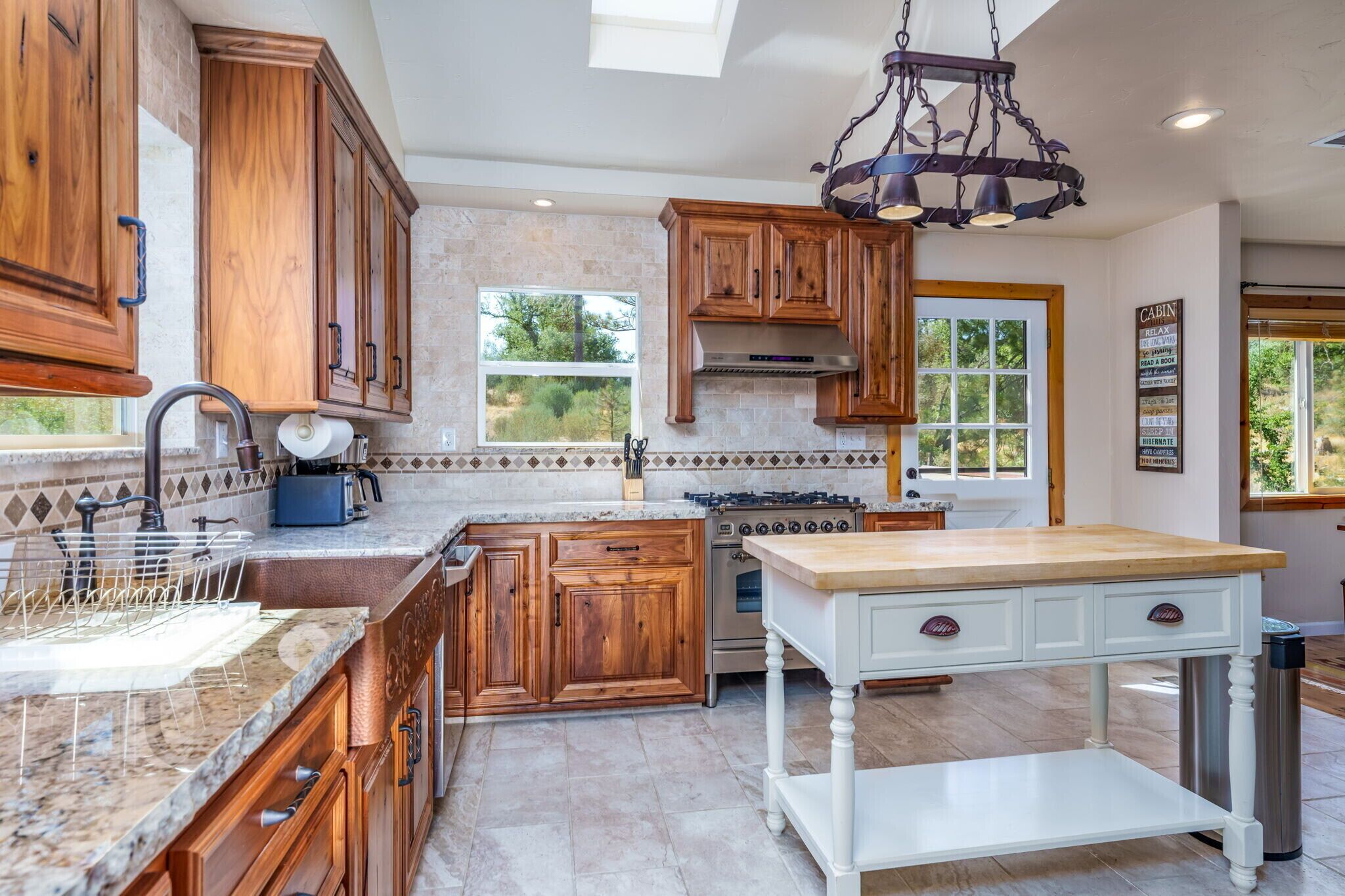 A kitchen with wooden cabinets, a built-in stove, and a large island.