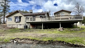 A two-story house with a balcony, a garage, and a small pond in front. - 🛶 Cozy Creek Cabin near Yosemite & Bass Lake (Ahwahnee)