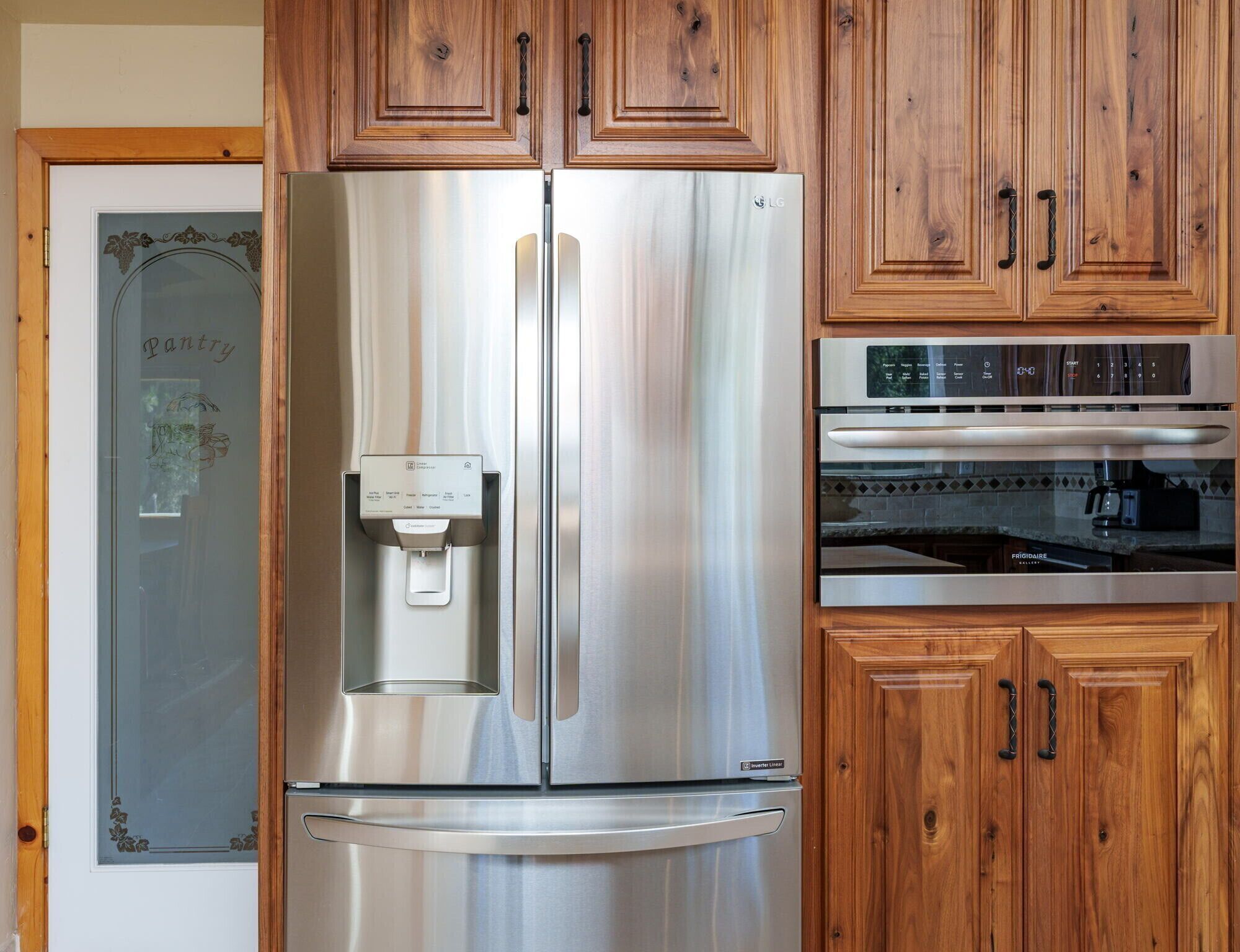 A stainless steel refrigerator with a water dispenser, a built-in oven, and a microwave.