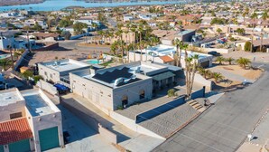 Un quartier résidentiel avec un grand immeuble doté d’une piscine sur le toit et de nombreux balcons.