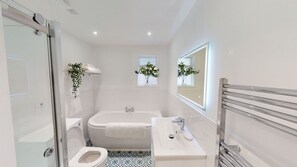 Bathtub, hair dryer, towels, toilet paper