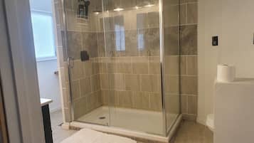 Chuveiro, toalhas de banho, sabonete, papel higiênico