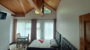 Une chambre avec deux lits, une table à manger et un téléviseur.