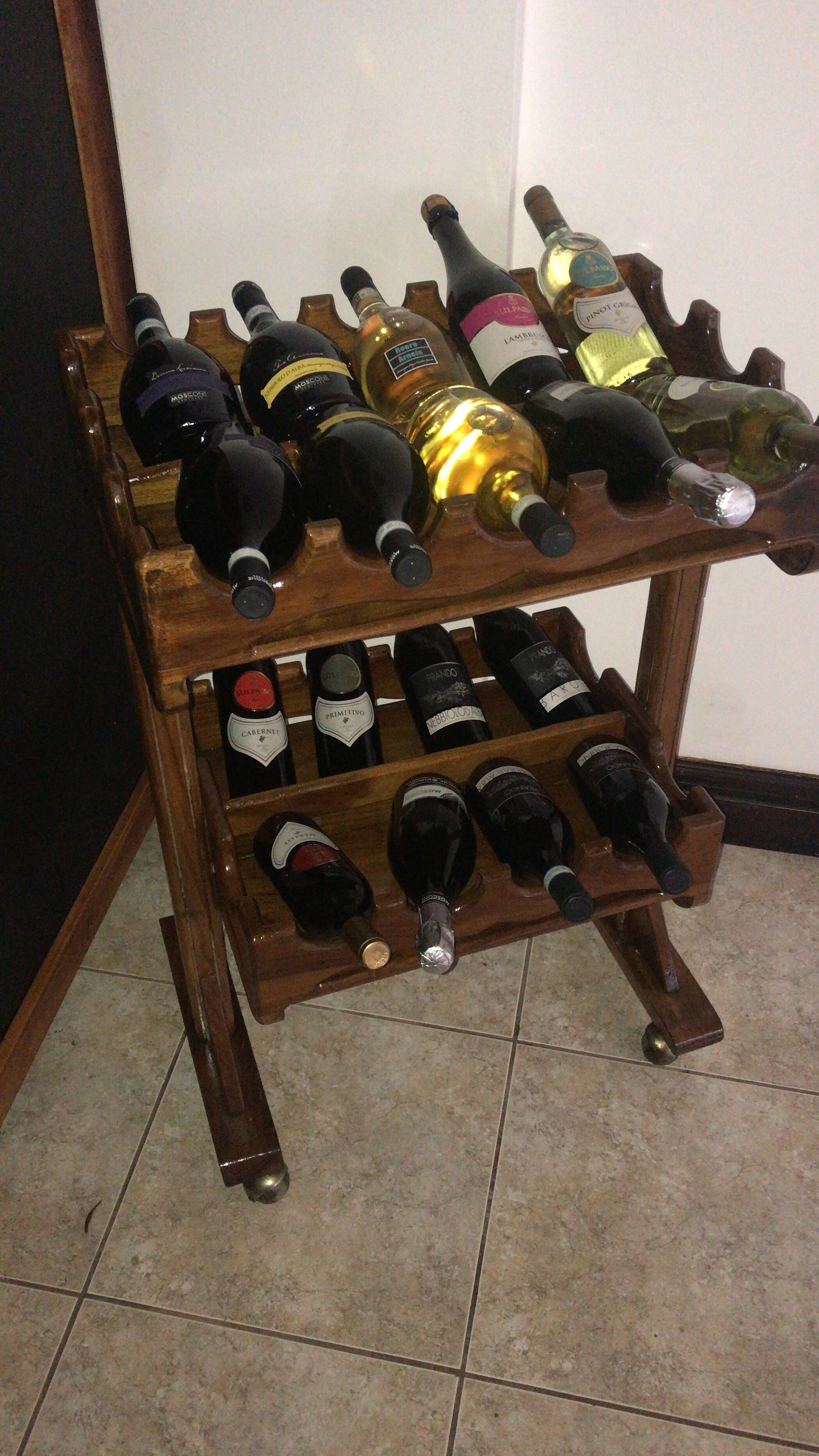 Una botellera de madera con varias botellas de vino.