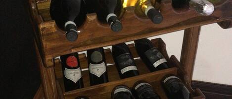 Una botellera de madera con varias botellas de vino.