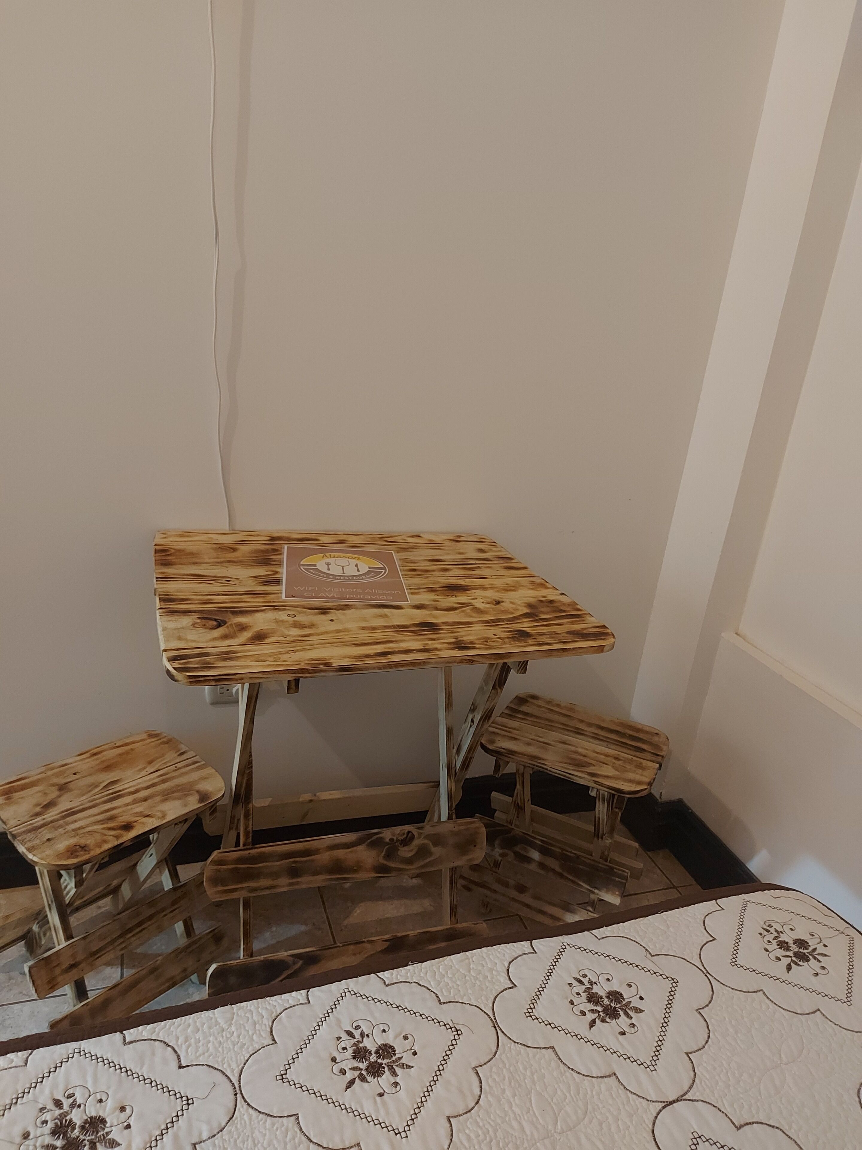 A corner table with a wooden top and a sign indicating it is a WiFi visitor's table.