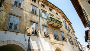 A historic building with multiple balconies, some with plants. - Residenza al Ponte in Arco (Arco)