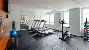 A gym with treadmills, an elliptical, and a weight rack. - Av0408 Studio Avanhandava (São Paulo)