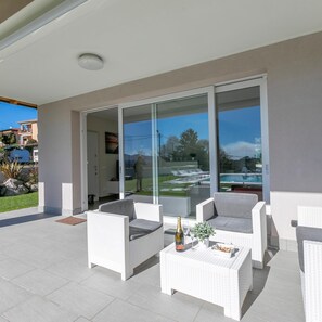 Relax in a serene outdoor space with a pool view, perfect for unwinding or socializing.