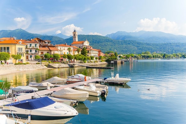 Enjoy serene lakeside views and access to a marina with boats, surrounded by a charming town with historic architecture.