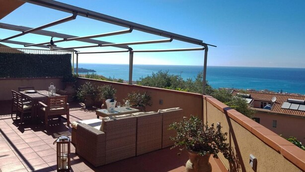 A terrace with a view of the sea, outdoor furniture, and a pergola structure. - Seascape Terrace Spacious Apartment With Terrace (Cefalù)