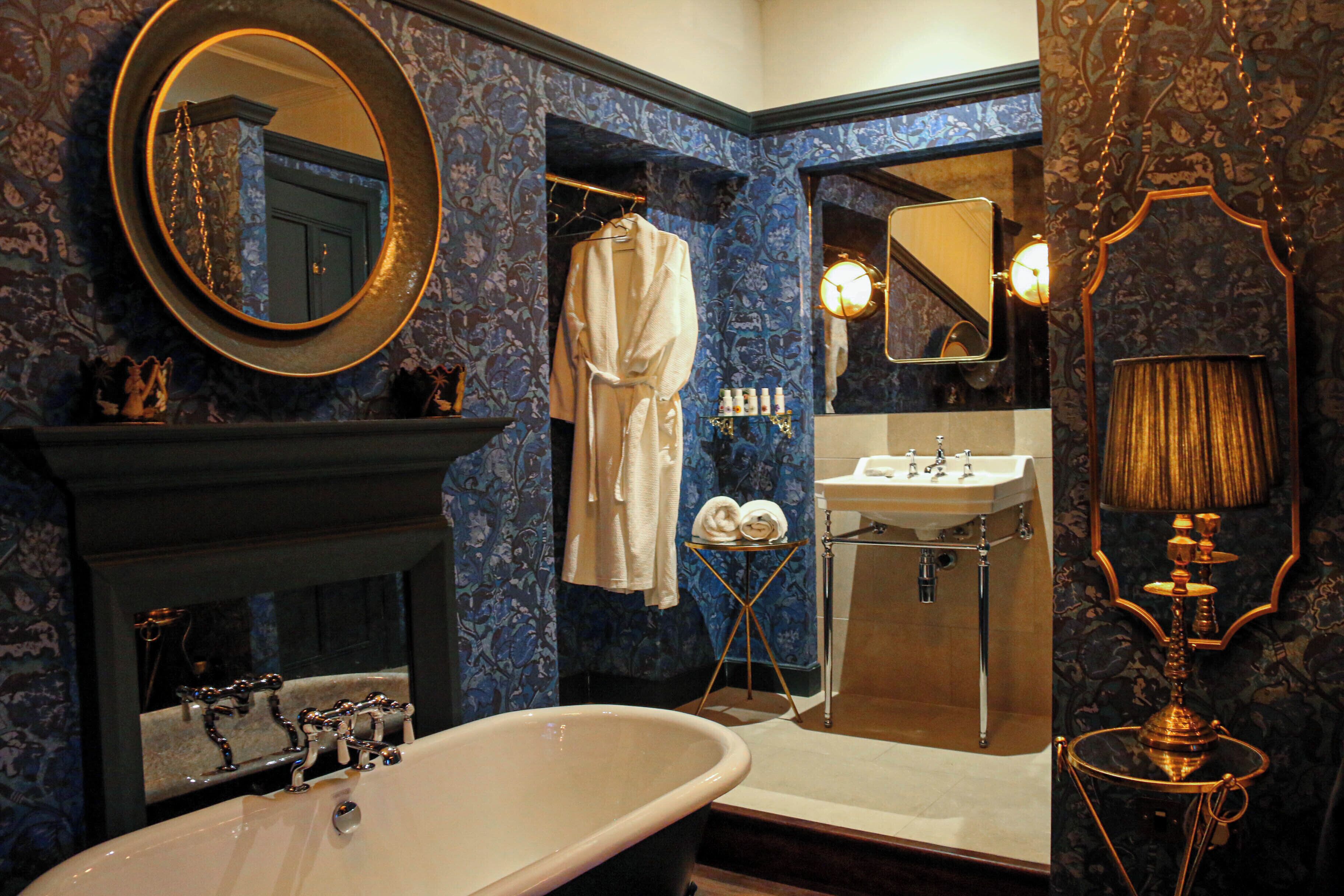 A bathroom with a freestanding bathtub, a mirror, a sink, and a vanity.