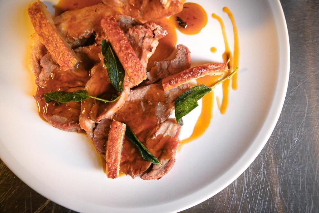 Une assiette de nourriture contenant de la viande et des herbes.