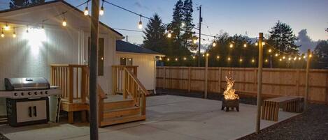 Spacious back patio with bench seating & fire pit