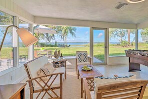 A spacious indoor area with a pool table, comfortable seating, and a view of the outdoors. - Waterfront Lake Dora Escape w/ Private Dock & Slip (Tavares)