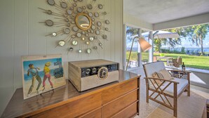 Una habitación con un aparador de madera, una radio antigua y un espejo montado en la pared.