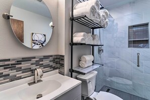 Une salle de bain au design moderne, comprenant un lavabo, des toilettes et des porte-serviettes.