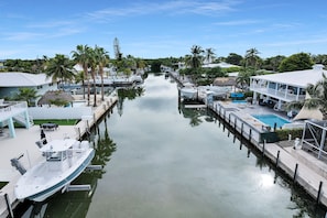 A marina with boats docked, a swimming pool, and a building with a balcony.
