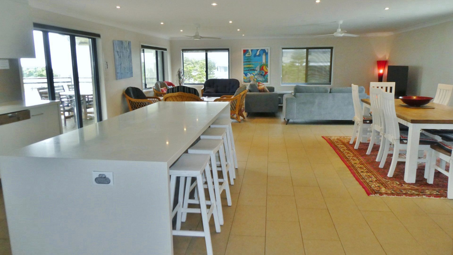 Amplia sala de estar con mesa y sillas de comedor, un sofá y una cocina con una isla grande.