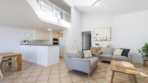 Un apartamento moderno con comedor, kitchenette y sala de estar.