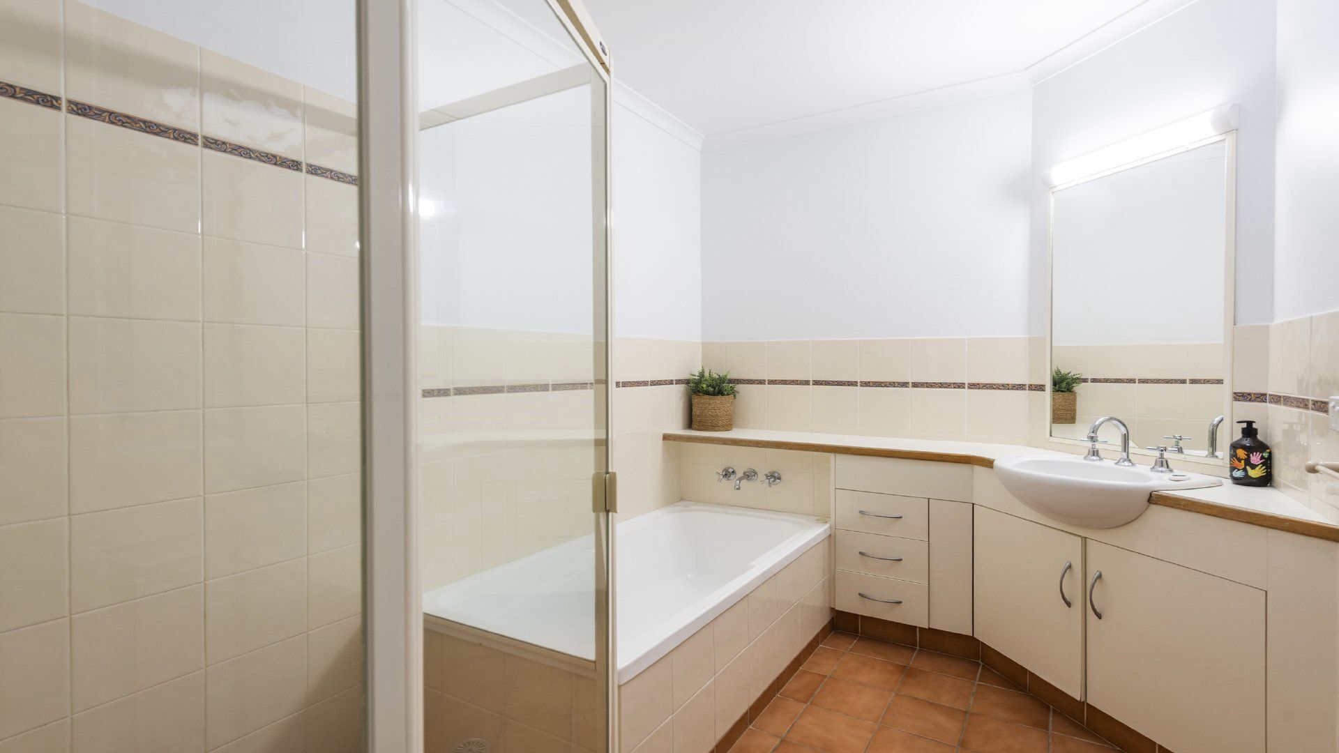 A bathroom with a bathtub, a sink, and a shower area.