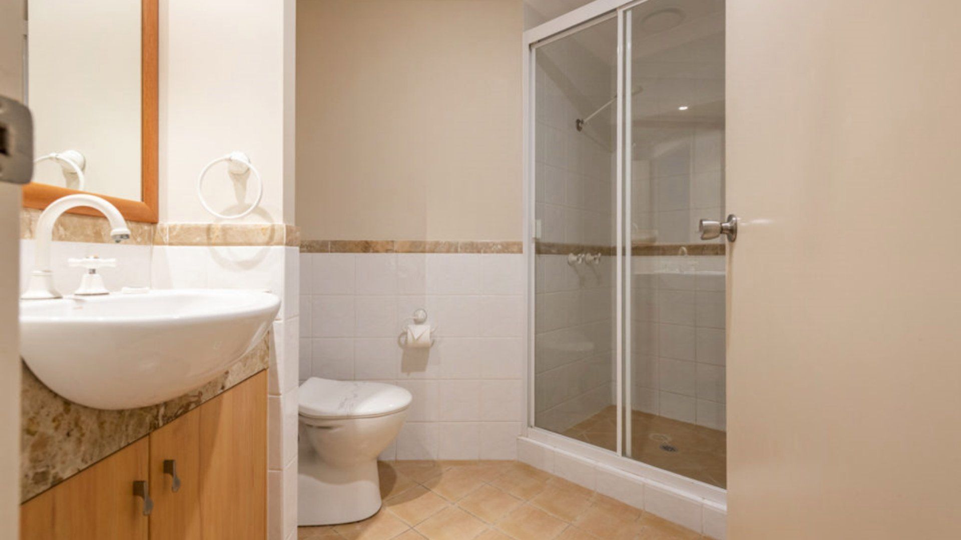 A bathroom with a sink, toilet, and glass-enclosed shower.
