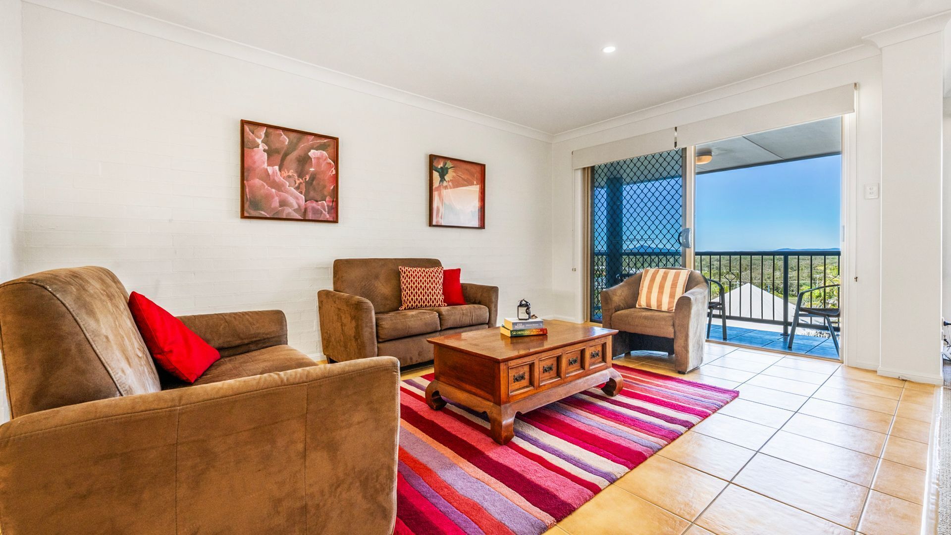 A living room with two sofas, a coffee table, and two paintings on the wall.