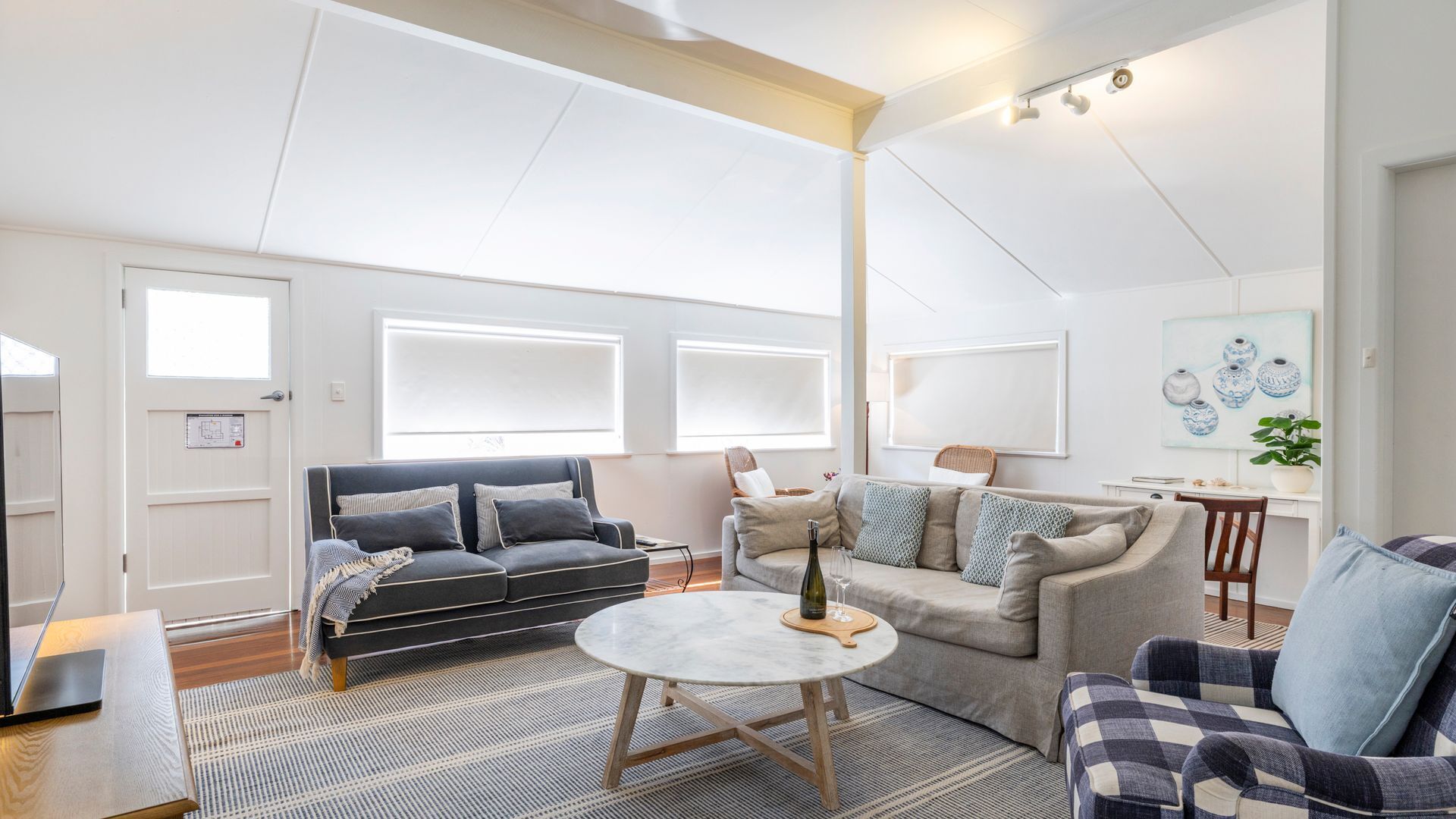 A modern living room with a sofa, armchair, and a round coffee table.