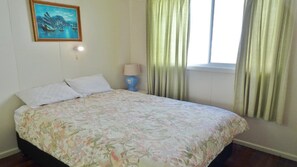 Cozy retreat with a single bed, nightstand, and a beautiful coastal painting.