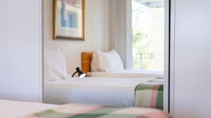 Una camera d'albergo con un letto, una lampada da comodino e una finestra vista esterna.