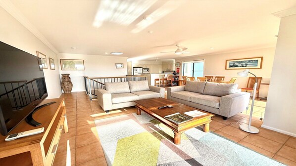 A spacious living room with a sofa set, a coffee table, and a television.