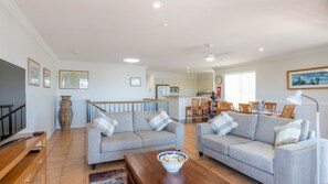 A spacious living area with two sofas, a coffee table, and a dining table set for four.