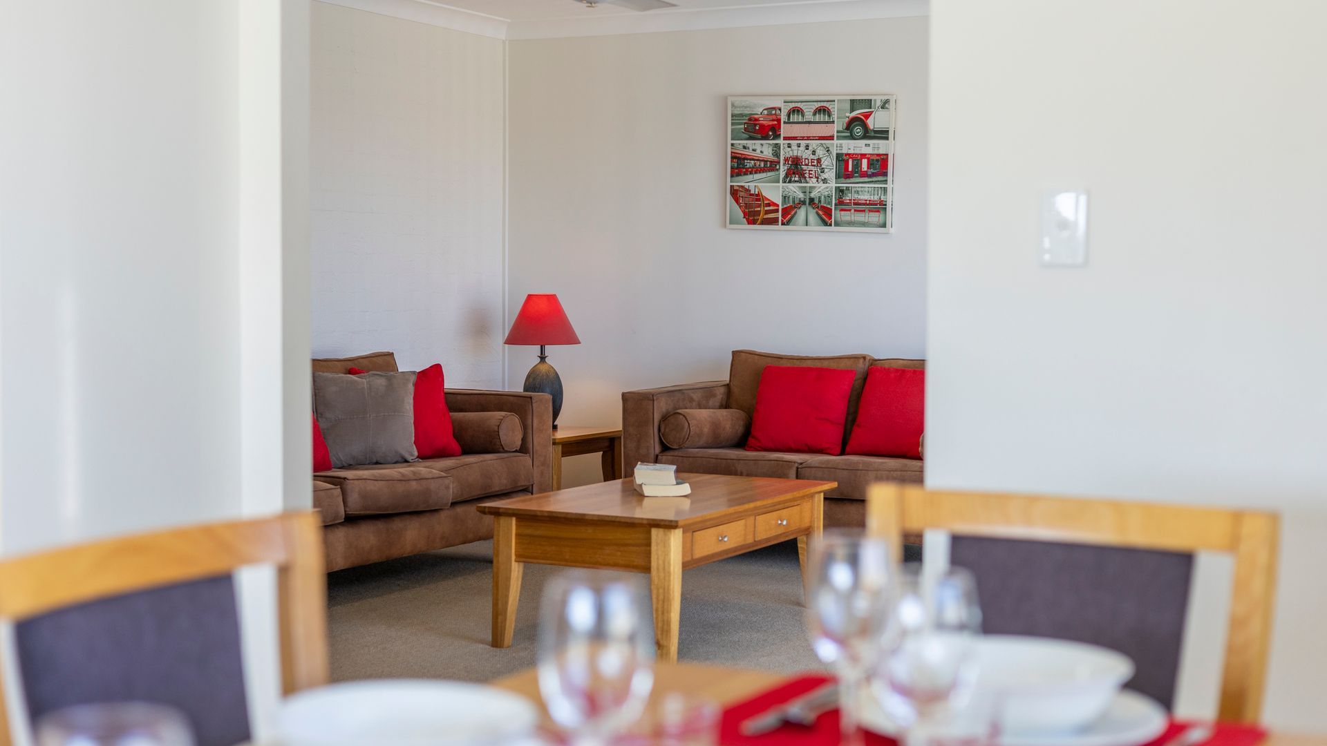 A living room with two sofas, a coffee table, and a dining table set for a meal.