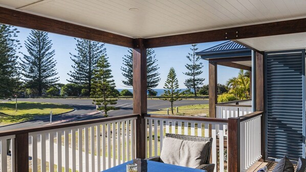 A covered outdoor area with a view of a road and trees. - Ocean Spirit - Lifestyle Yamba (YAMBA)