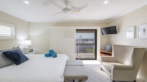 A hotel room with a bed, a chair, a television, and a view of a marina. - Marina Views - Lifestyle Yamba (YAMBA)