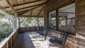 A wooden deck with a covered area, two wicker chairs, and a table. - The Point - Lifestyle Yamba (ANGOURIE)
