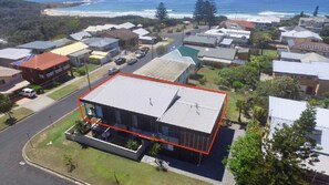 Stunning ocean views surround this modern home with large windows and a flat roof.