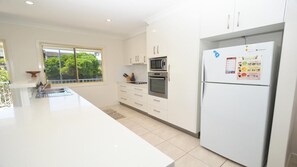 Enjoy cooking in this well-equipped kitchen with a large island, sink, stainless steel oven, and refrigerator.