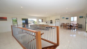 Enjoy a spacious interior with a high ceiling, open-plan area, and a wooden staircase leading to an upper level.