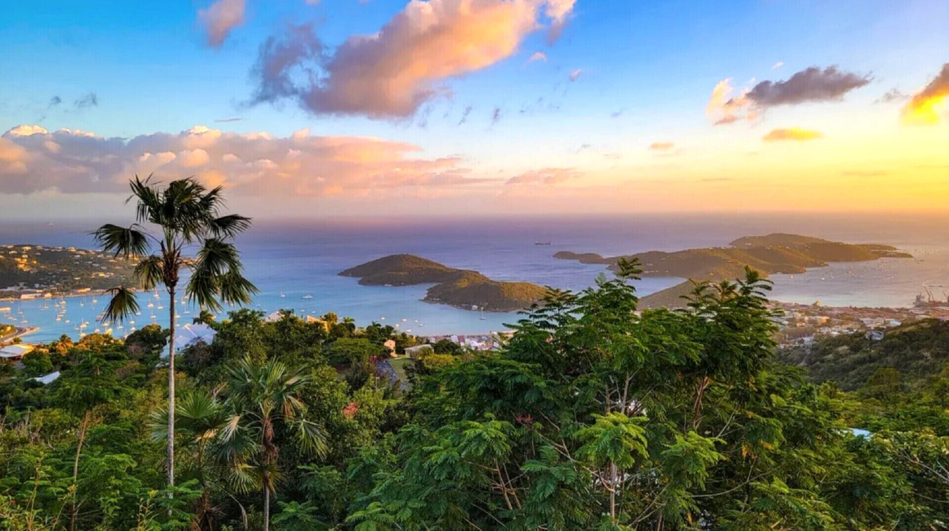 A coastal landscape with lush greenery, a clear view of the sea, and distant islands.