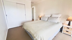 A bedroom with a bed, bedside tables, a wardrobe, and a lamp.