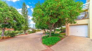 A residential street with a driveway leading to a house with a garage. - The Sands Unit 59 - Lifestyle Yamba (YAMBA)