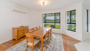Enjoy meals in this dining area with a large table and six chairs, surrounded by a beautiful view.