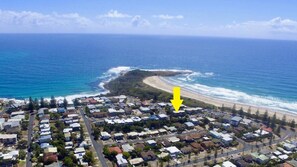 An aerial view of a coastal residential area with houses, roads, and a beach. - Romiaka Unit 10 - Lifestyle Yamba (YAMBA)