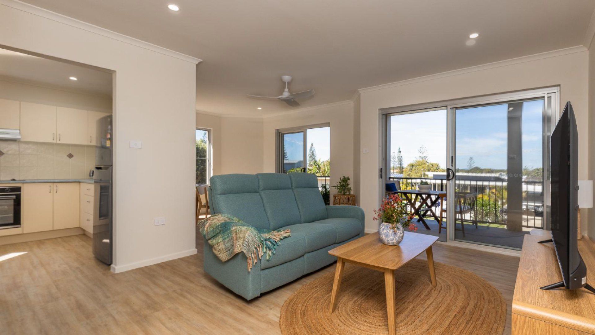 Un salon moderne avec un canapé, une table basse et un balcon offrant une vue agréable.